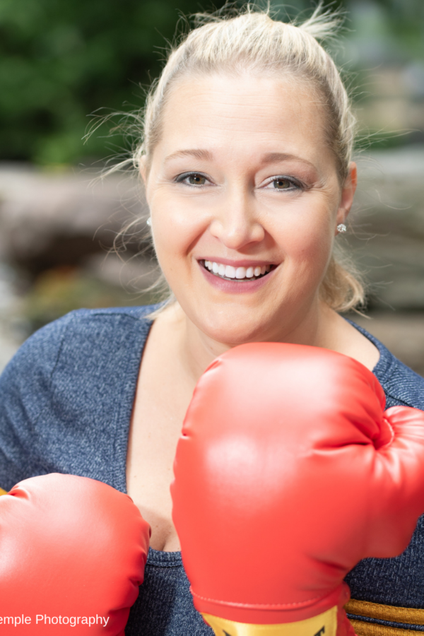 Confident woman with boxing gloves smiling at the camera